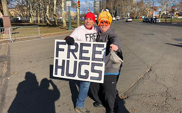 people holding free hugs sign