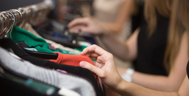 People looking through clothes on hangers