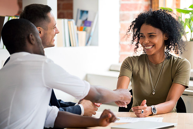 Woman shaking hands with man in a meeting.