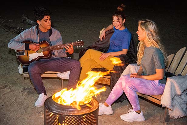 Young people in front of camp fire
