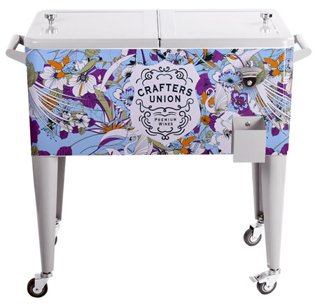 Large metal cooler on wheels, colorful design on front.