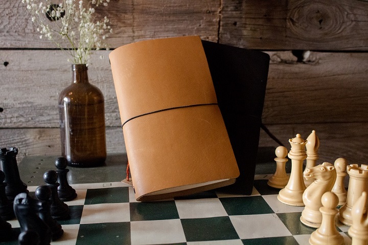 Leather-bound journal on chess board