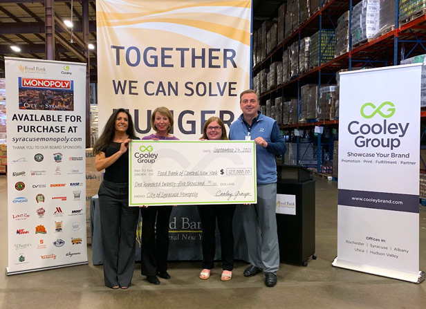 four people holding up large check for food bank