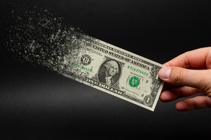 dollar bill in hand disintegrating