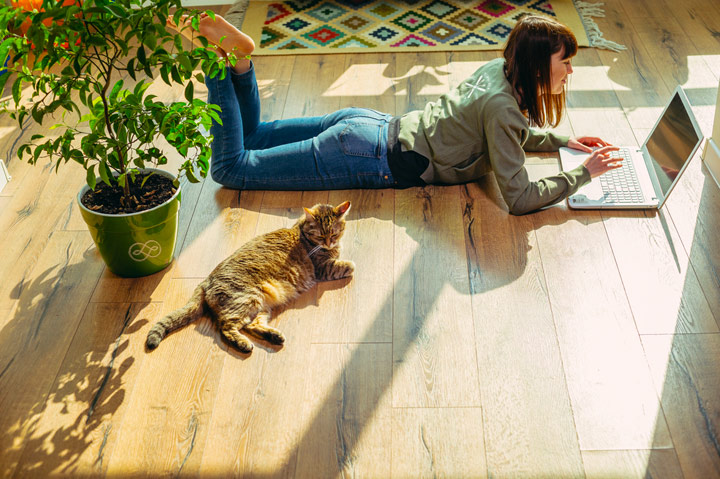 woman lying on floor typing on laptop