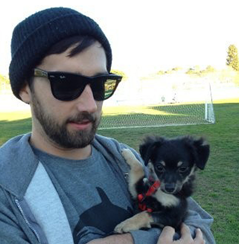 man wearing sunglasses holding small dog