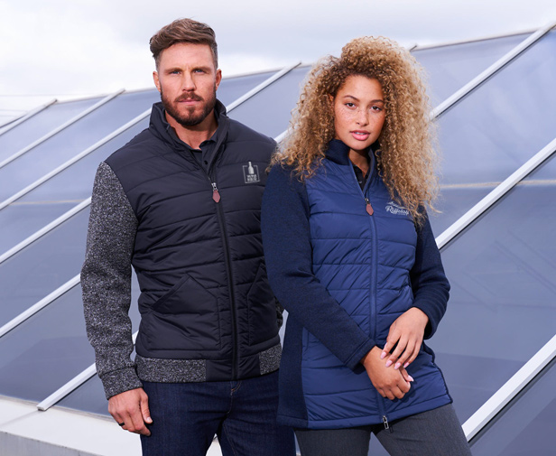 man standing behind woman, both wearing quilted jackets