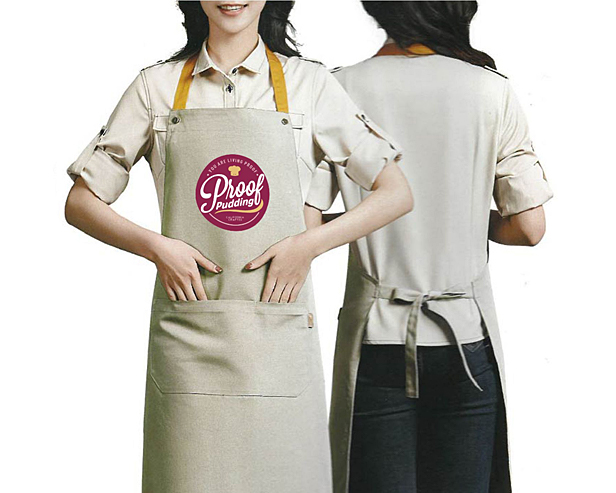 woman wearing tan apron, hands in pockets