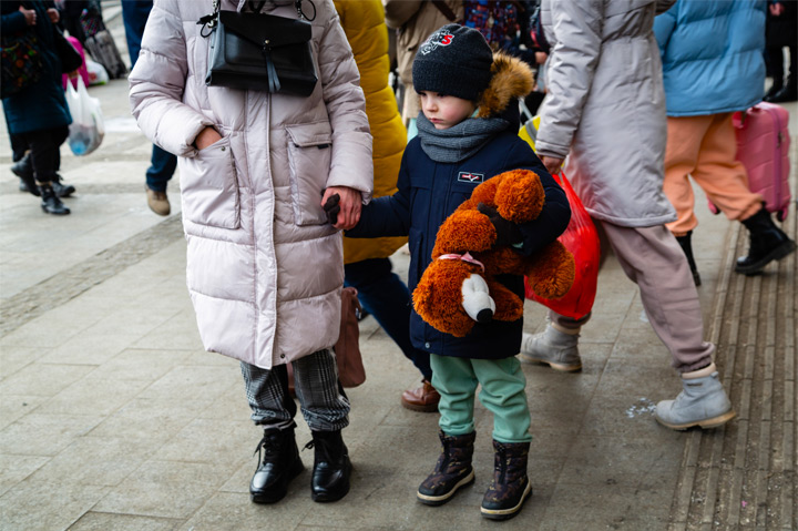 young Ukrainian refugee hugging teddy bear