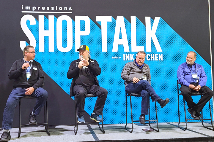 four men sitting on a stage in chairs with Shop Talk sign behind