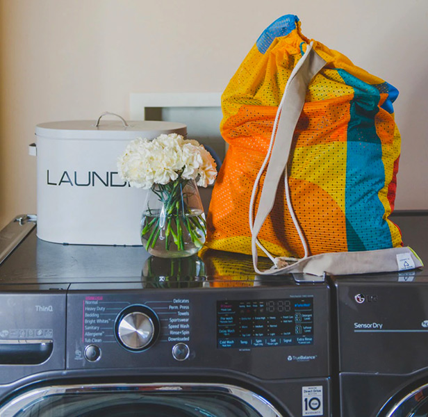 multi-color drawstring laundry bag on top of washing machine