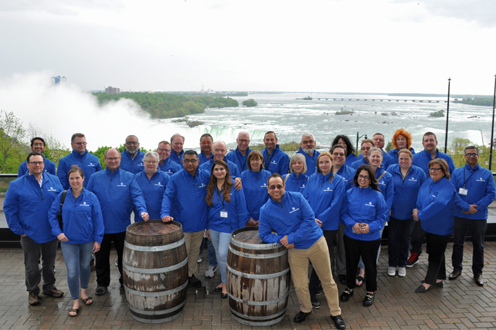 Fully Promoted group standing on deck, Niagara Falls behind