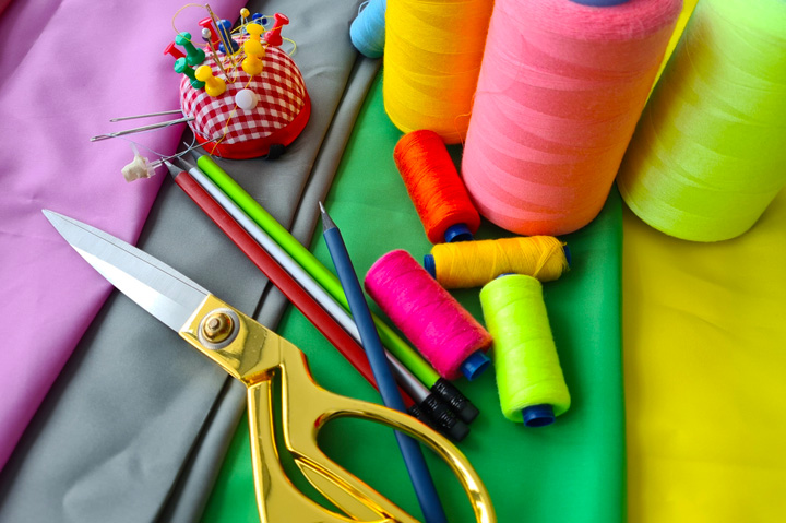 brightly colored fabric, thread and scissors