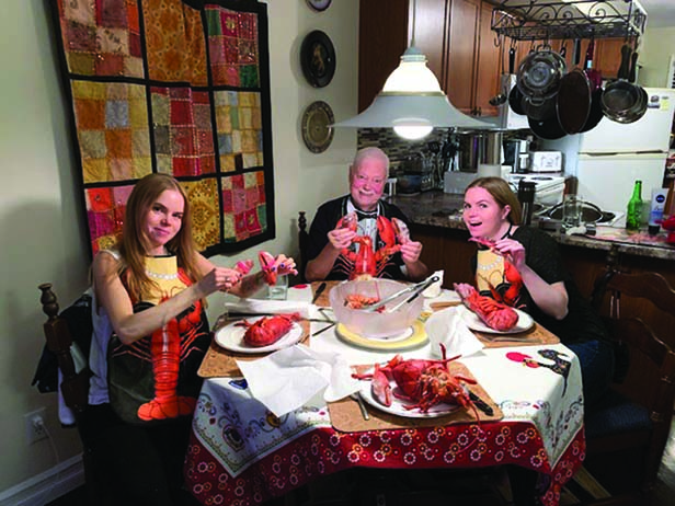 Oesen with his twin daughters, Amanda (left) and Amber, cracking into some lobster.