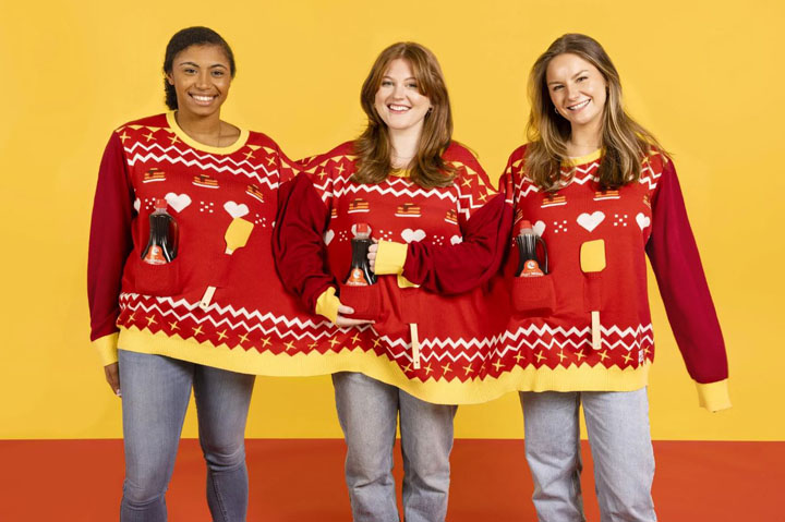 three women wearing one sweater