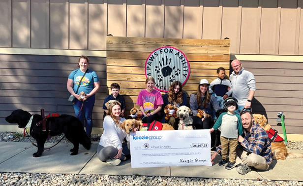 people posing with dogs and large donation check