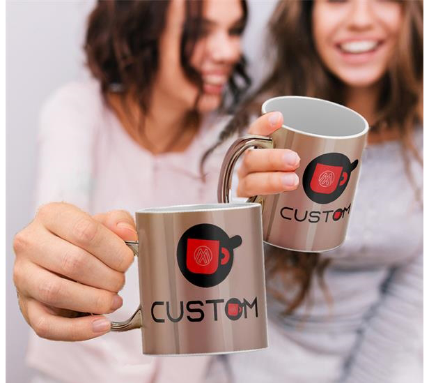 two women holding metallic coffee mugs