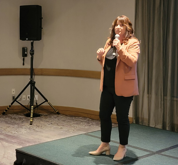 woman talking into microphone on a small stage