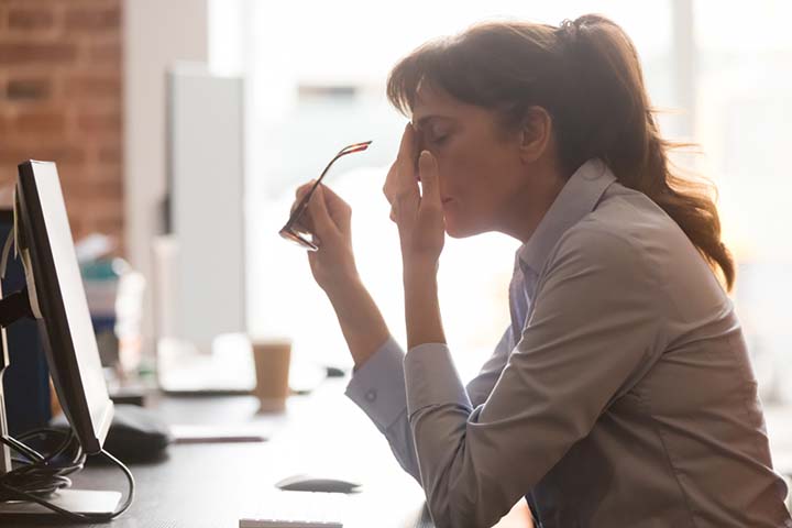 Exhausted and frustrated young woman rubbing her head