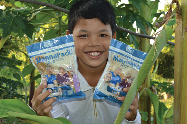 young boy holding packages of Manna