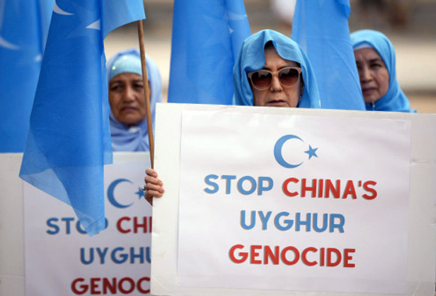 protesters holding stop China's genocide signs